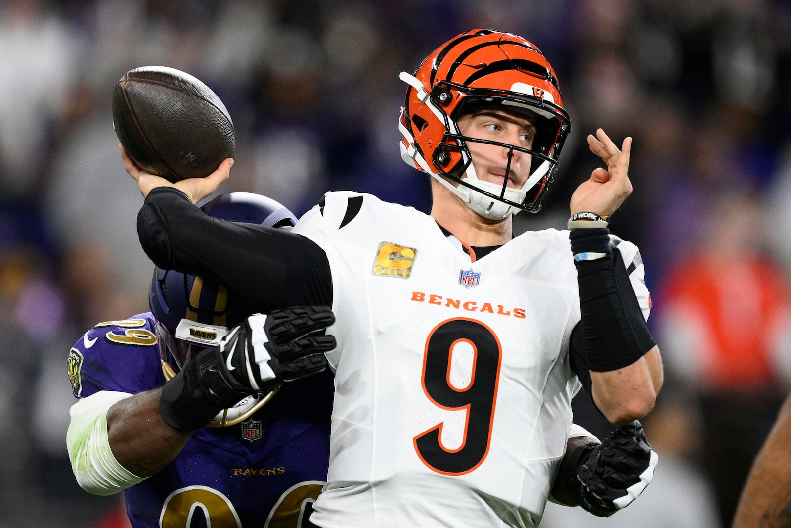 Baltimore Ravens linebacker Odafe Oweh, left, pressures Cincinnati Bengals quarterback Joe Burrow (9) as he passes the ball during the first half of an NFL football game, Thursday, Nov. 7, 2024, in Baltimore. (AP Photo/Nick Wass)