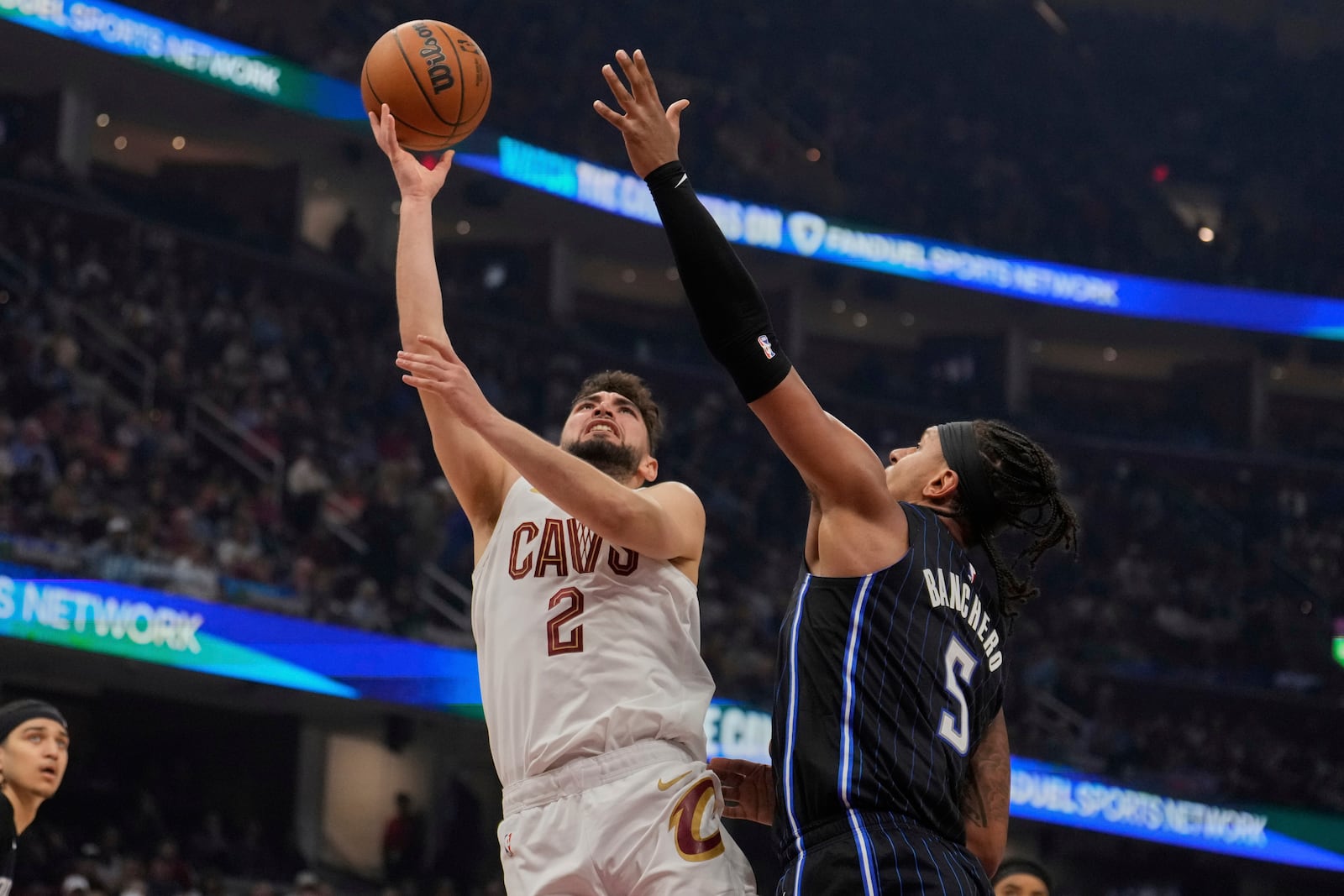 Cleveland Cavaliers guard Ty Jerome (2) shoots next to Orlando Magic forward Paolo Banchero (5) in the first half of an NBA basketball game Sunday, March 16, 2025, in Cleveland. (AP Photo/Sue Ogrocki)