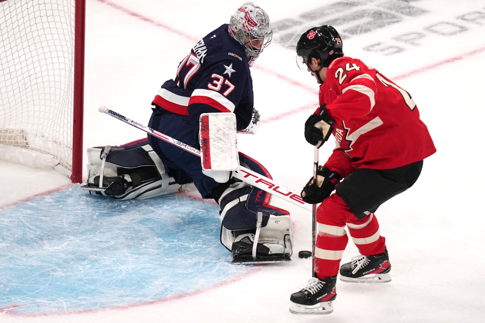 United States goalie Connor Hellebuyck, left, stops a shot by Canada's Seth Jarvis during the first period of the 4 Nations Face-Off championship hockey game, Thursday, Feb. 20, 2025, in Boston. (AP Photo/Charles Krupa)