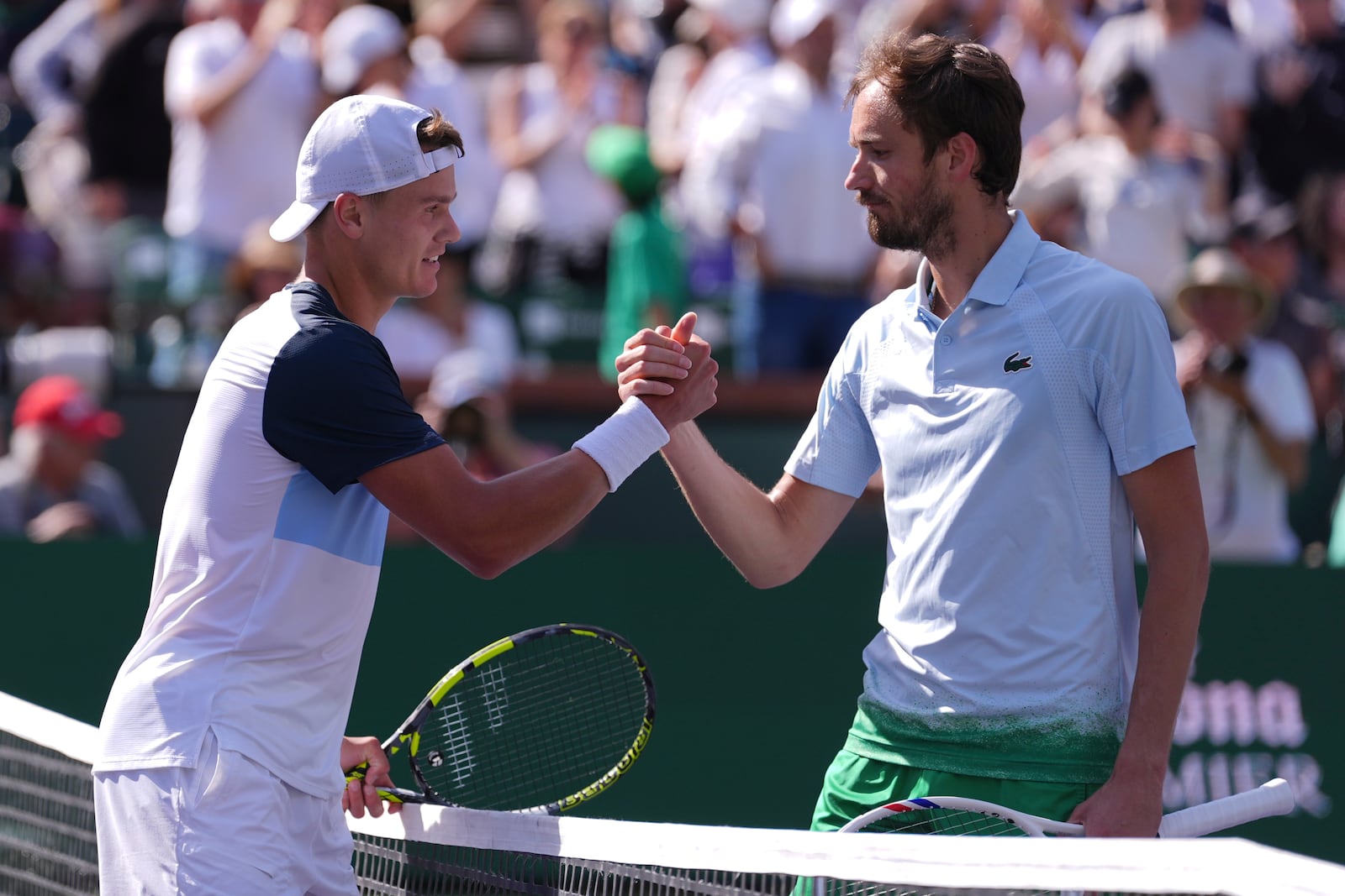 Holger Rune, of Denmark, left, shakes hands with Daniil Medvedev, of Russia, after defeating him in their semifinals match at the BNP Paribas Open tennis tournament Saturday, March 15, 2025, in Indian Wells, Calif. (AP Photo/Mark J. Terrill)