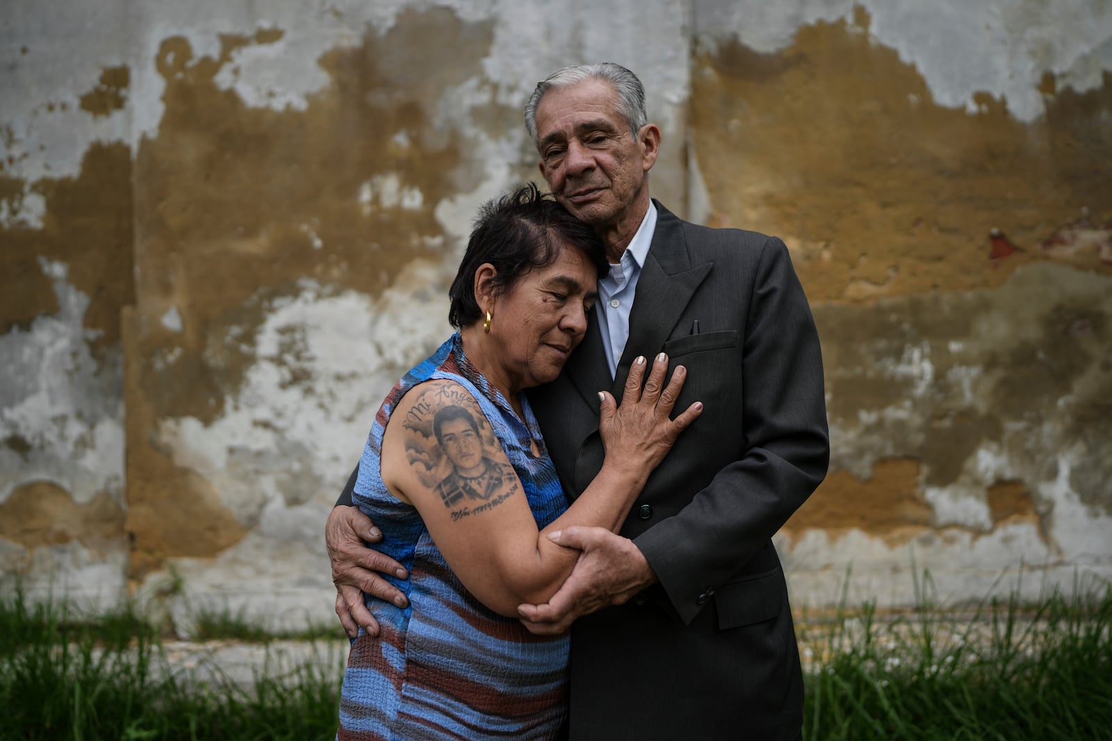 Doris Tejada, left, and Dario Morales embrace as they pose for a portrait in Bogota, Colombia, Tuesday, Nov. 5, 2024. The couple said their son disappeared in 2007 near the Venezuelan border and became a "false positive," a civilian intentionally registered as a rebel and slain by the military. (AP Photo/Ivan Valencia)