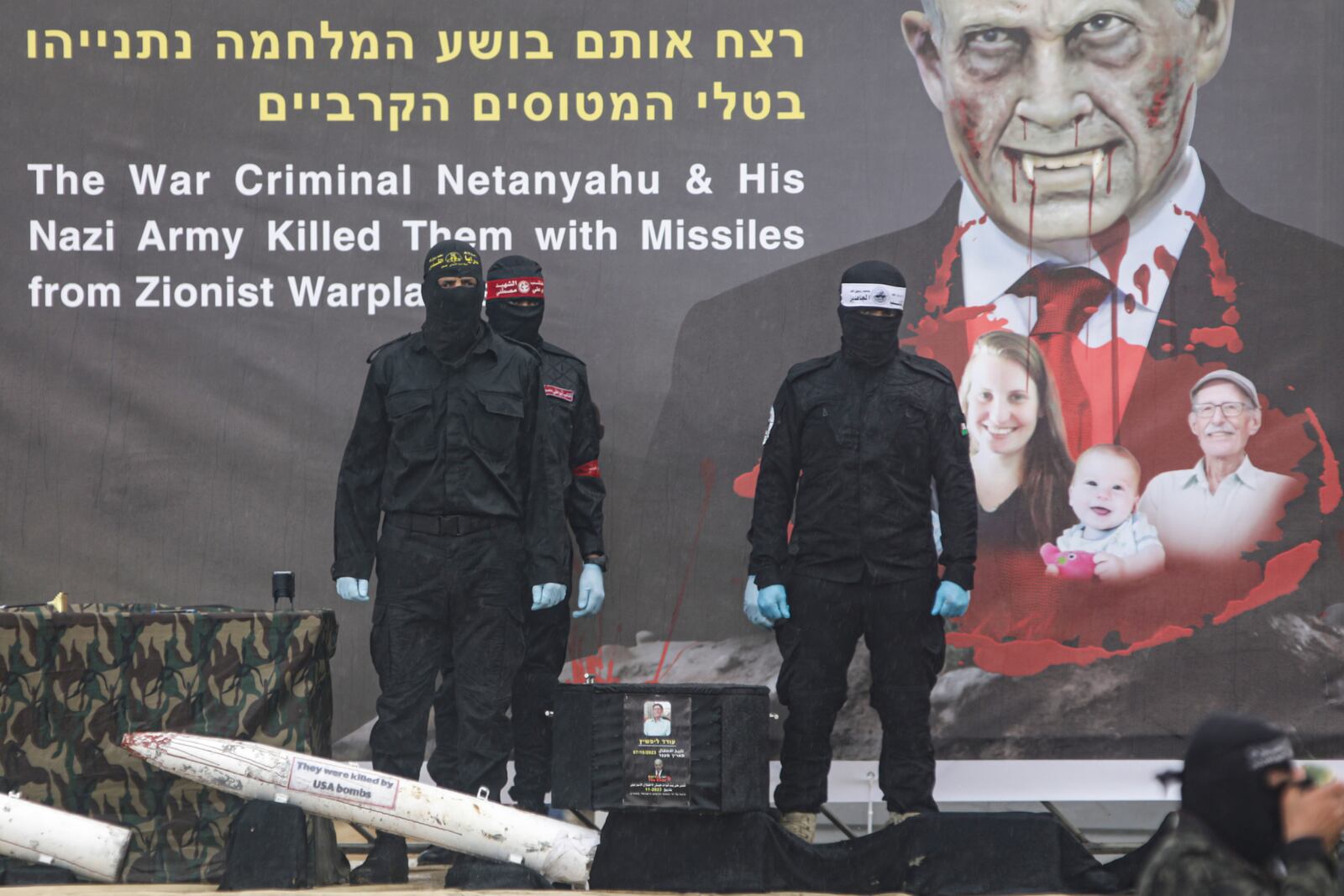 Palestinian fighters stand next to a coffin containing the body of Oded Lifshitz, one of four Israeli hostages, to hand it over to the Red Cross in Khan Younis, southern Gaza Strip, Thursday, Feb. 20, 2025. (AP Photo/Jehad Alshrafi)