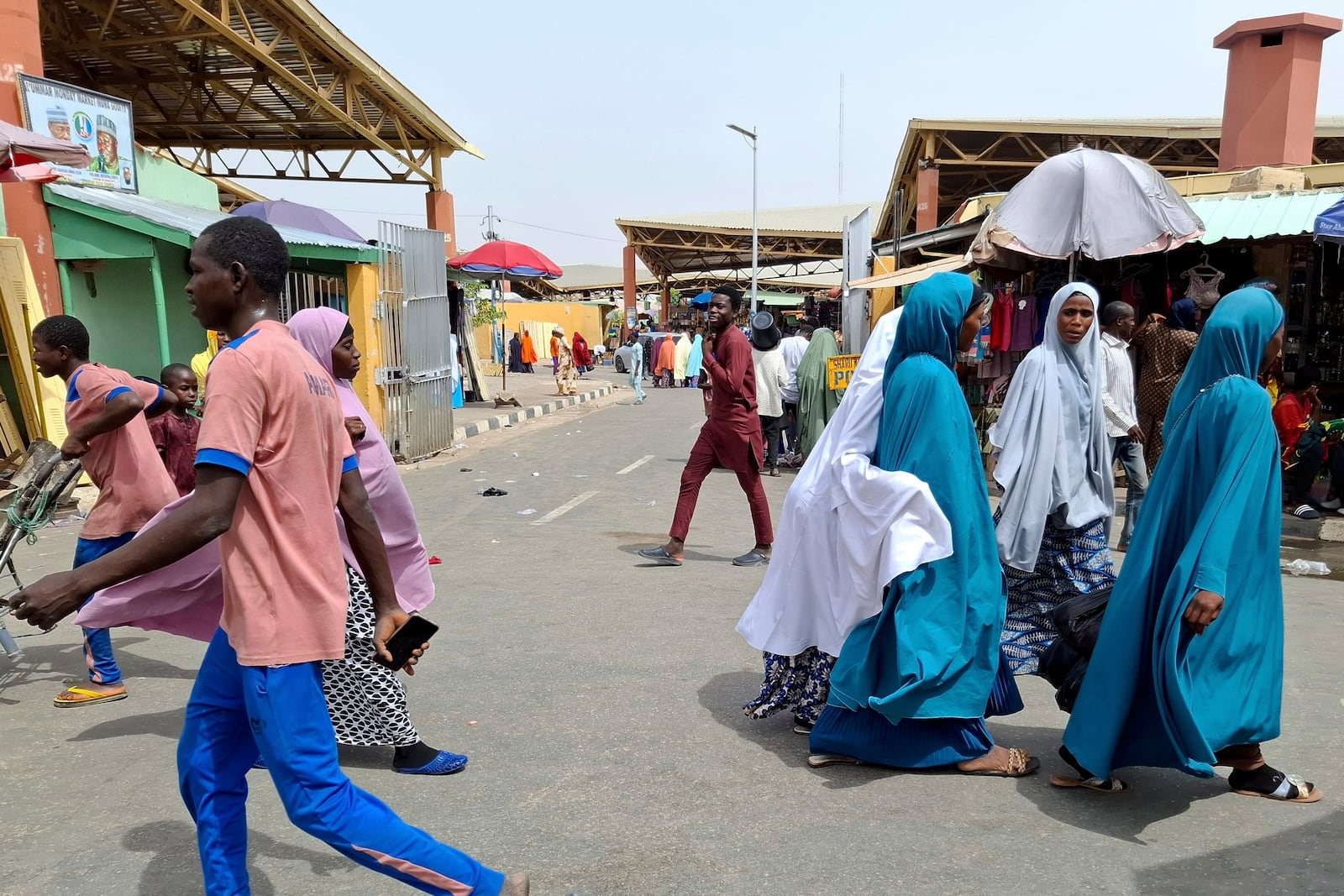 People walk past the main market in Maiduguri, Nigeria, Saturday, March 15, 2025. (AP Photo/Joshua Olatunji)