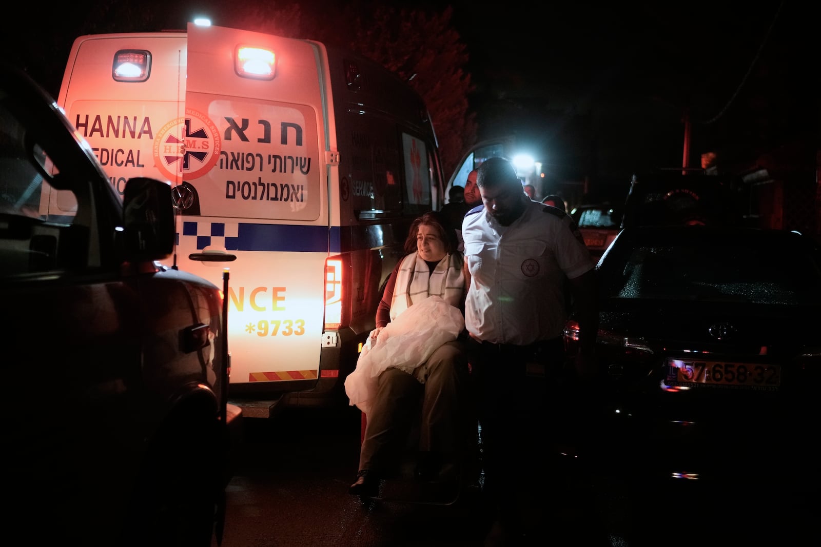 Medics assist a woman evacuated from the area where building was hit by a rocket fired from Lebanon in Shefa-Amr in northern Israel, on Monday, Nov. 18, 2024. A woman was killed and several others were injured. (AP Photo/Leo Correa)