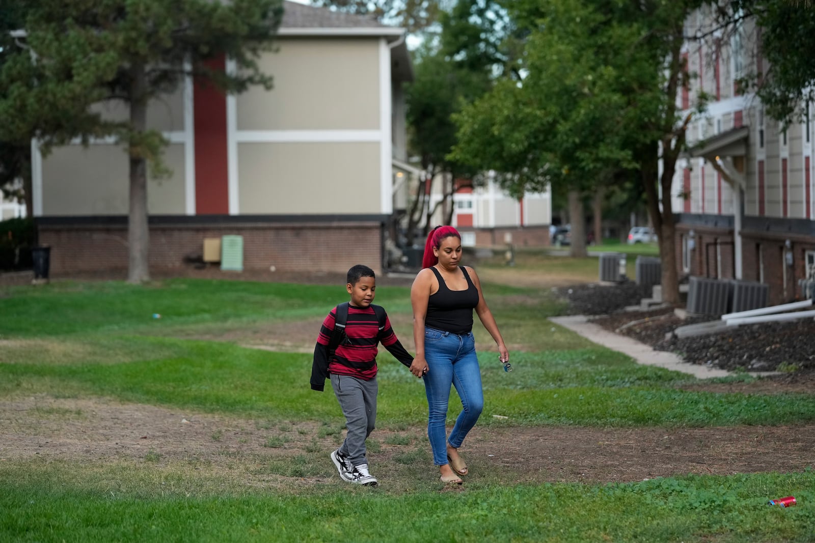 Gabriela Ramírez, right, walks her son Dylan to school Thursday, Aug. 29, 2024, in Aurora, Colo. (AP Photo/Godofredo A. Vásquez)