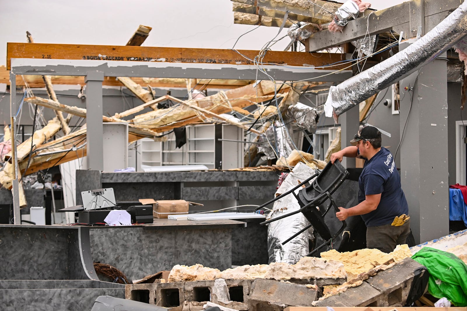 Dustin Halcom of the Cord Fire Department helps salvage what's left of the Walling Drug store Saturday, March 15, 2025 after it was destroyed by a severe storm that ripped through Cave City, Ark., late Friday night. (Staci Vandagriff/Arkansas Democrat-Gazette via AP)