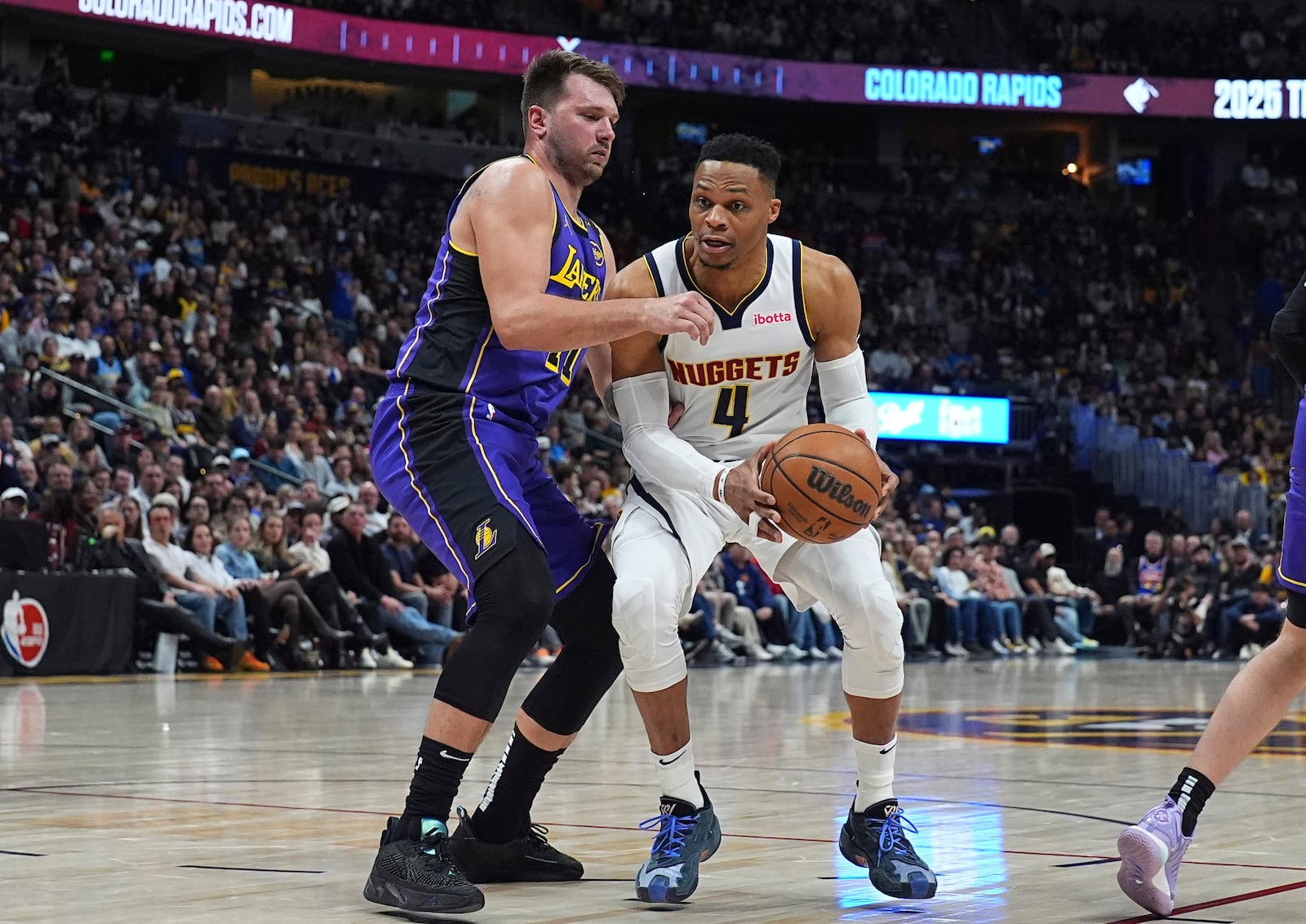 Denver Nuggets guard Russell Westbrook, right, drives the lane as Los Angeles Lakers guard Luka Doncic, left, defends in the second half of an NBA basketball game Saturday, Feb. 22, 2025, in Denver. (AP Photo/David Zalubowski)