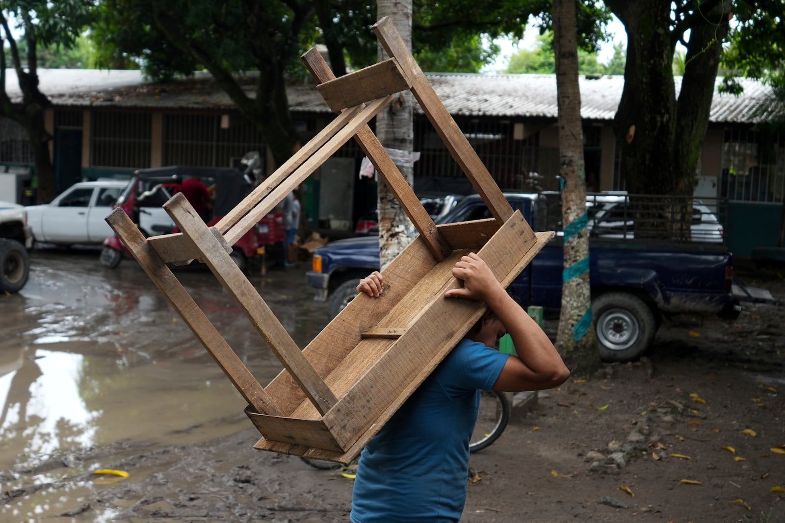 A man carries a table at a temporary shelter in the Suyapa neighborhood partially flooded by the Ulúa River's overflow after Tropical Storm Sara, in Potrerillos, Honduras, Sunday, Nov. 17, 2024. (AP Photo/Moises Castillo)