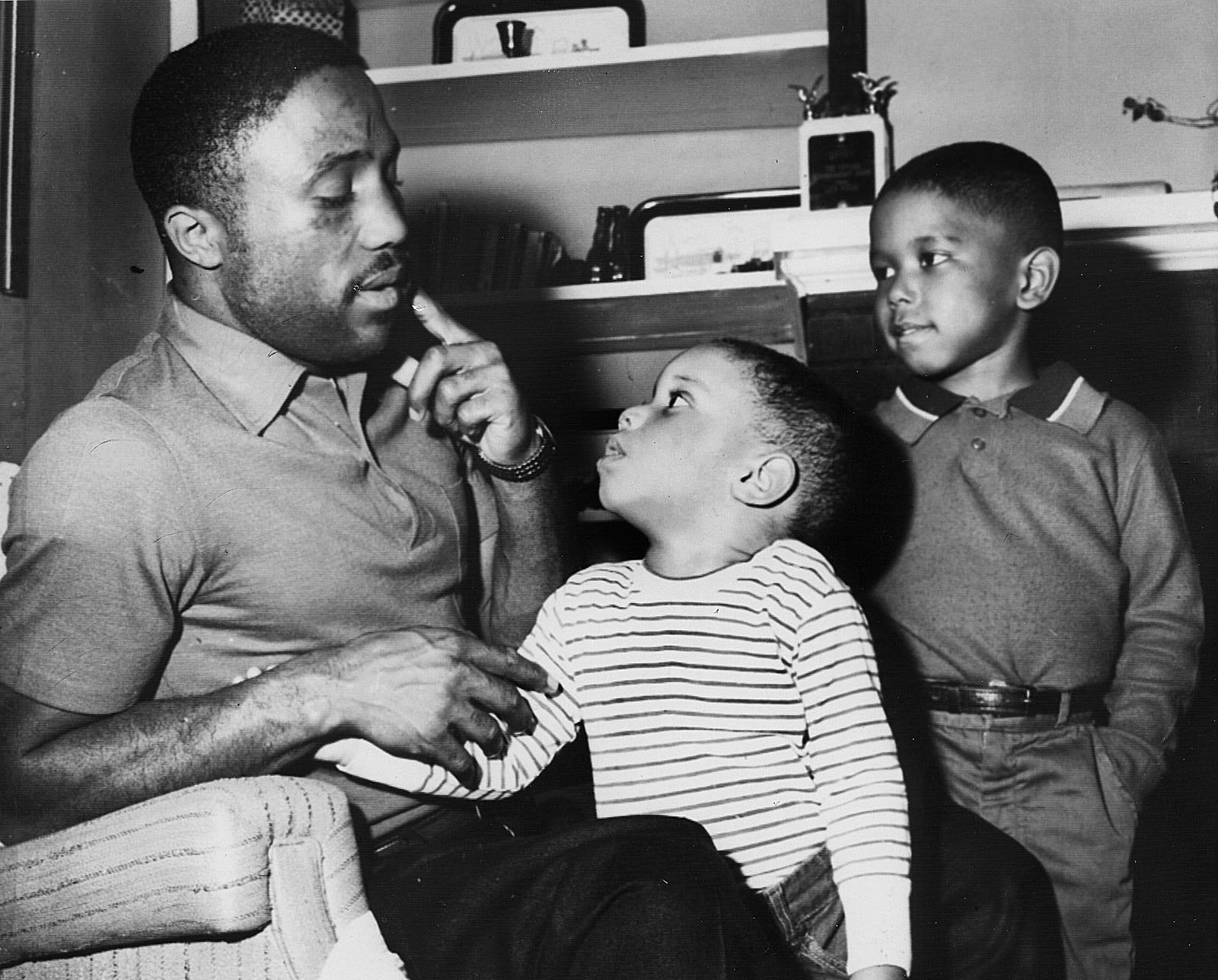 Springfield's boxer Davey Moore showing his sons, David (center) and Rickey his broken jaw which he suffered in a fight with Carlos Hernandez in Caracas, Venezuela. Photo taken March 18, 1960.