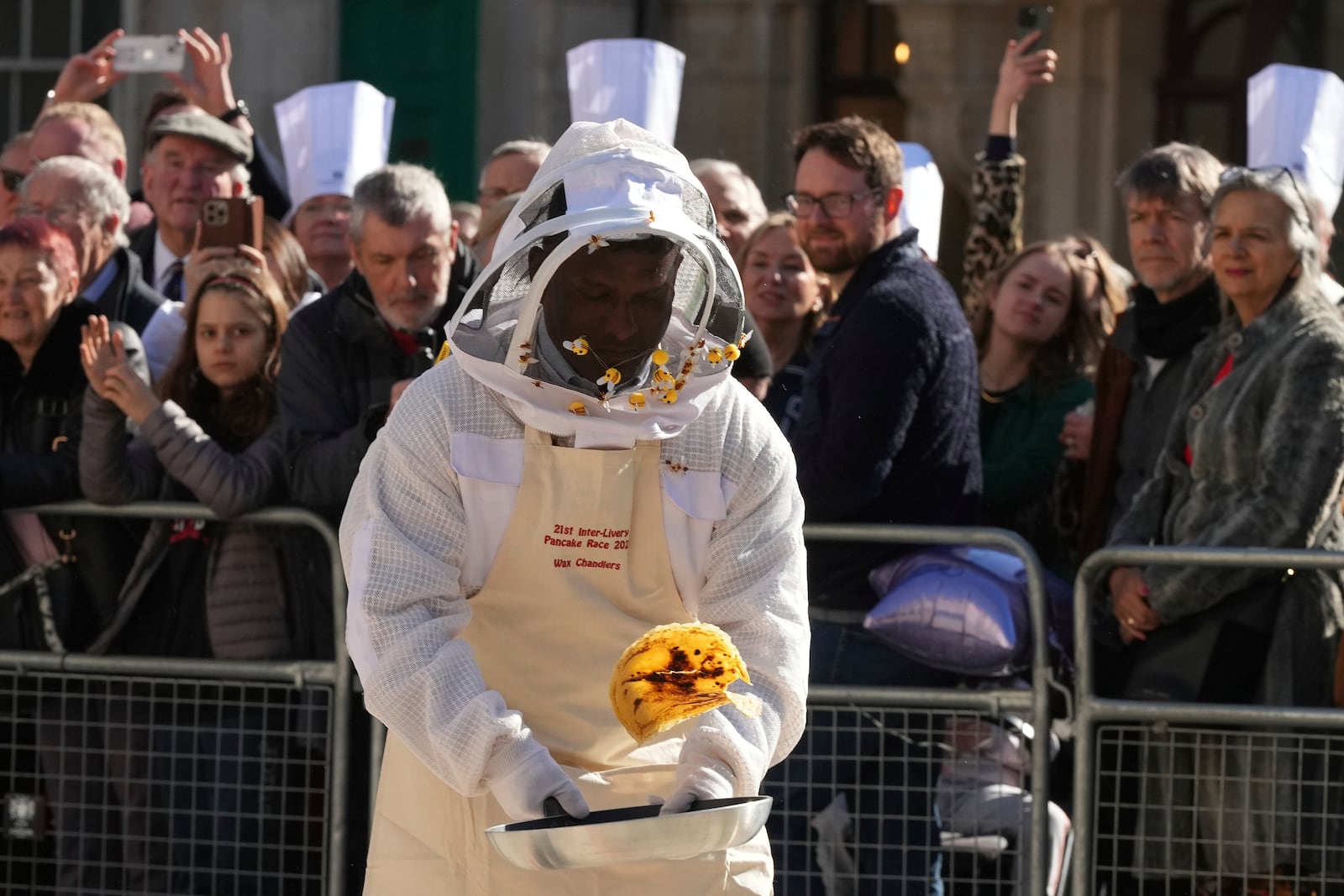 A competitor flips a pancake during a traditional pancake race by livery companies at the Guildhall in London, Tuesday, March 4, 2025.(AP Photo/Frank Augstein)