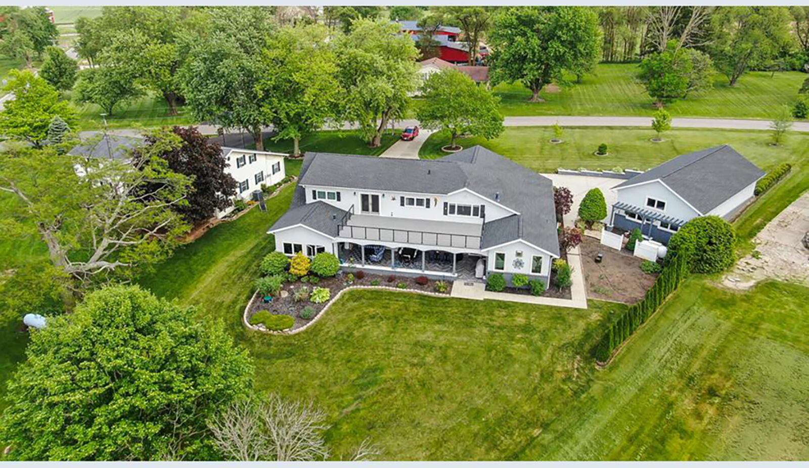 The rear of the home features a 39' x 15' wood balcony with railings on the second level with lake views, a covered porch with an outdoor kitchen, and a double-sided gas fireplace with a hot tub room.