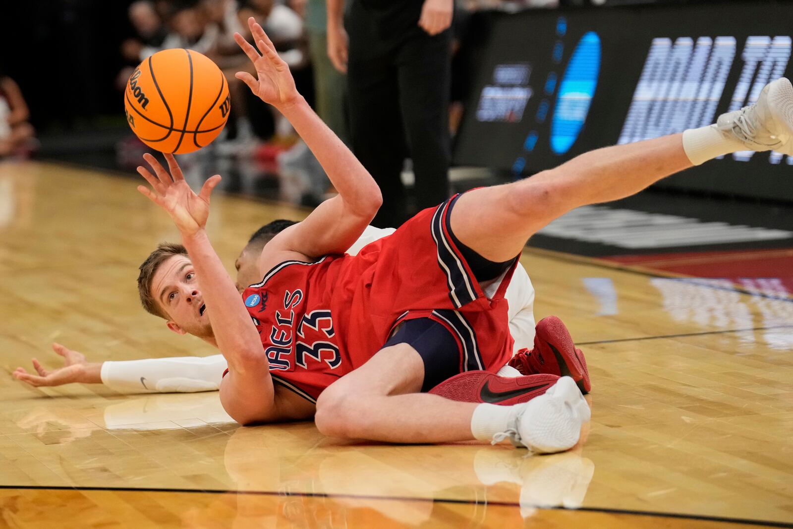 Saint Mary's forward Luke Barrett (33) passes the ball in front of Alabama forward Jarin Stevenson, rear, in the second half in the second round of the NCAA college basketball tournament, Sunday, March 23, 2025, in Cleveland. (AP Photo/Sue Ogrocki)