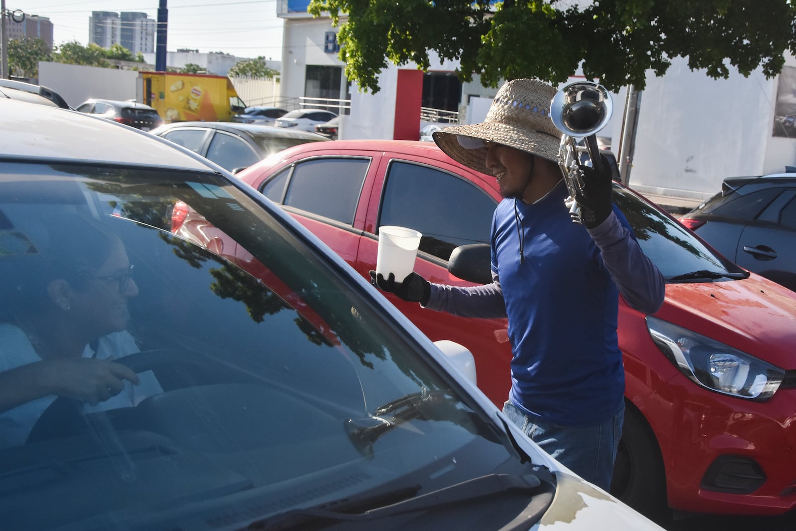 A musician collects tips from motorists in Culiacan, Sinaloa state, Mexico, Monday, Oct. 14, 2024. (AP Photo)