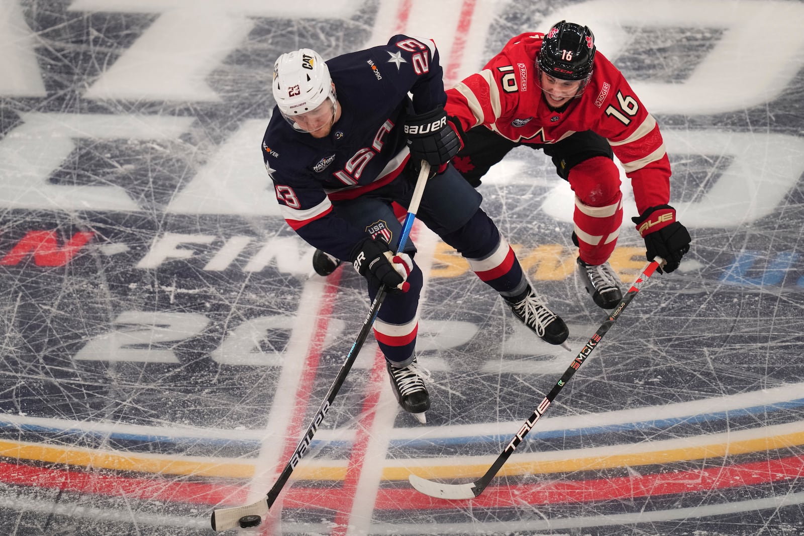 United States' Adam Fox, left, battles Canada's Mitch Marner for the puck during the first period of the 4 Nations Face-Off championship hockey game, Thursday, Feb. 20, 2025, in Boston. (AP Photo/Charles Krupa)