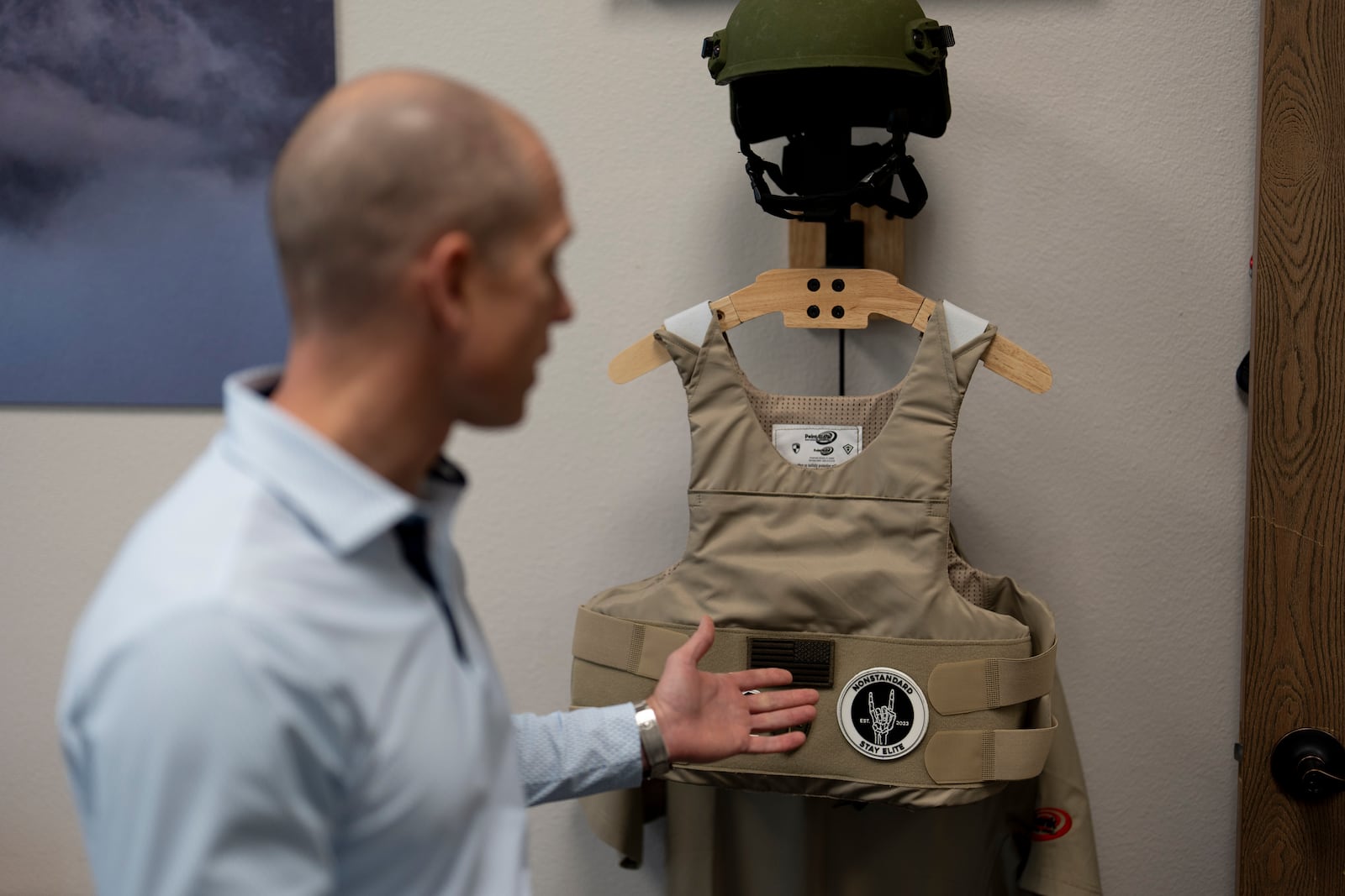 Veteran and business owner Jackson Dalton gestures towards protective gear at the Black Box Safety offices, Thursday, Nov. 7, 2024, in El Cajon, Calif. (AP Photo/Gregory Bull)