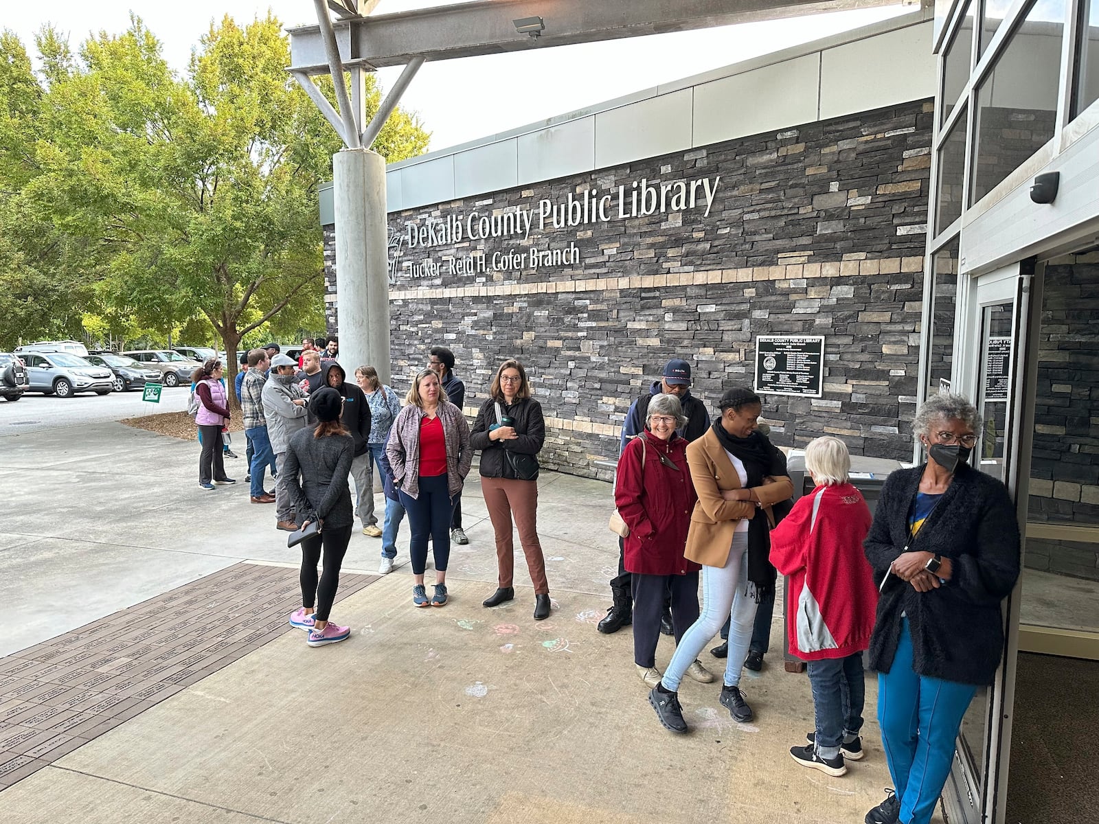 People line up to vote in the Atlanta suburb of Tucker, Ga., on Tuesday, Oct. 15, 2024, the first day of early in-person voting in Georgia. (AP Photo/Jeff Amy)