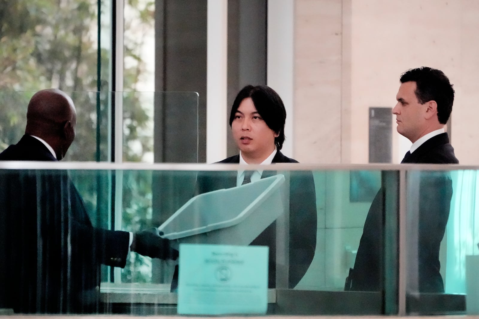 Ippei Mizuhara, center, former interpreter for Los Angeles Dodgers baseball star Shohei Ohtani arrives at federal court with his attorney Michael G. Freedman, right, for sentencing for bank and tax fraud on Thursday, Feb. 6, 2025, in Santa Ana, Calif. (AP Photo/Damian Dovarganes)