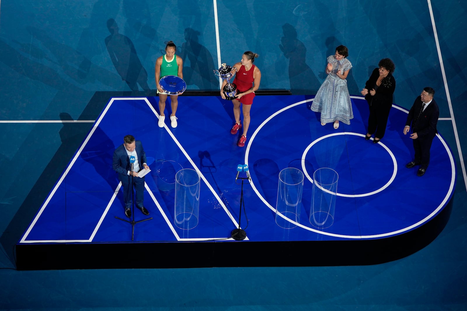 FILE - Aryna Sabalenka of Belarus, center, holds the Daphne Akhurst Memorial Cup after defeating Zheng Qinwen of China, second left, in the women's singles final at the Australian Open tennis championships at Melbourne Park, Melbourne, Australia, Jan. 27, 2024. (AP Photo/Louise Delmotte, File)