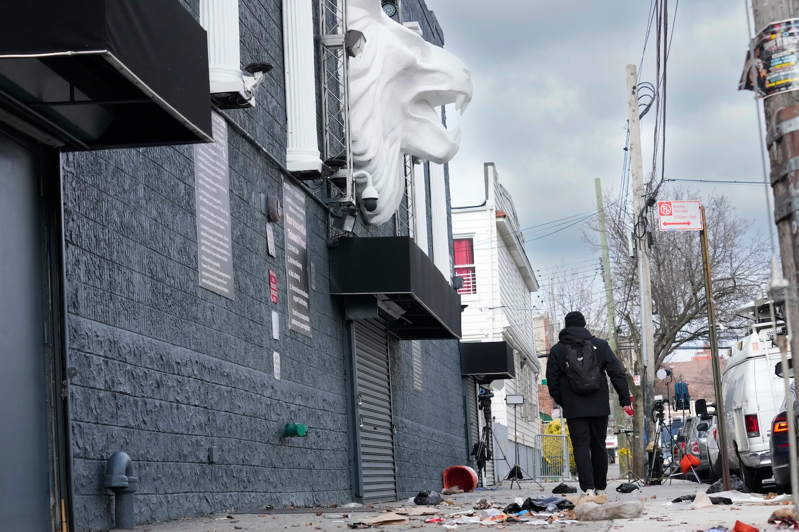 Members of the media work in front of the nightclub Amazura, left, in the Queens borough of New York, Thursday, Jan. 2, 2025. (AP Photo/Seth Wenig)