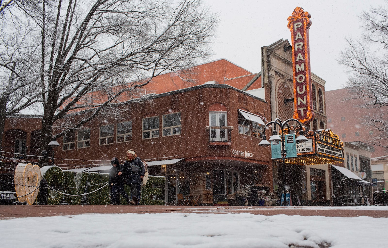 People walk along the Downtown Mall as a winter snowstorm hits Charlottesville, Va., Tuesday, Feb. 11, 2025. (Cal Cary/The Daily Progress via AP)