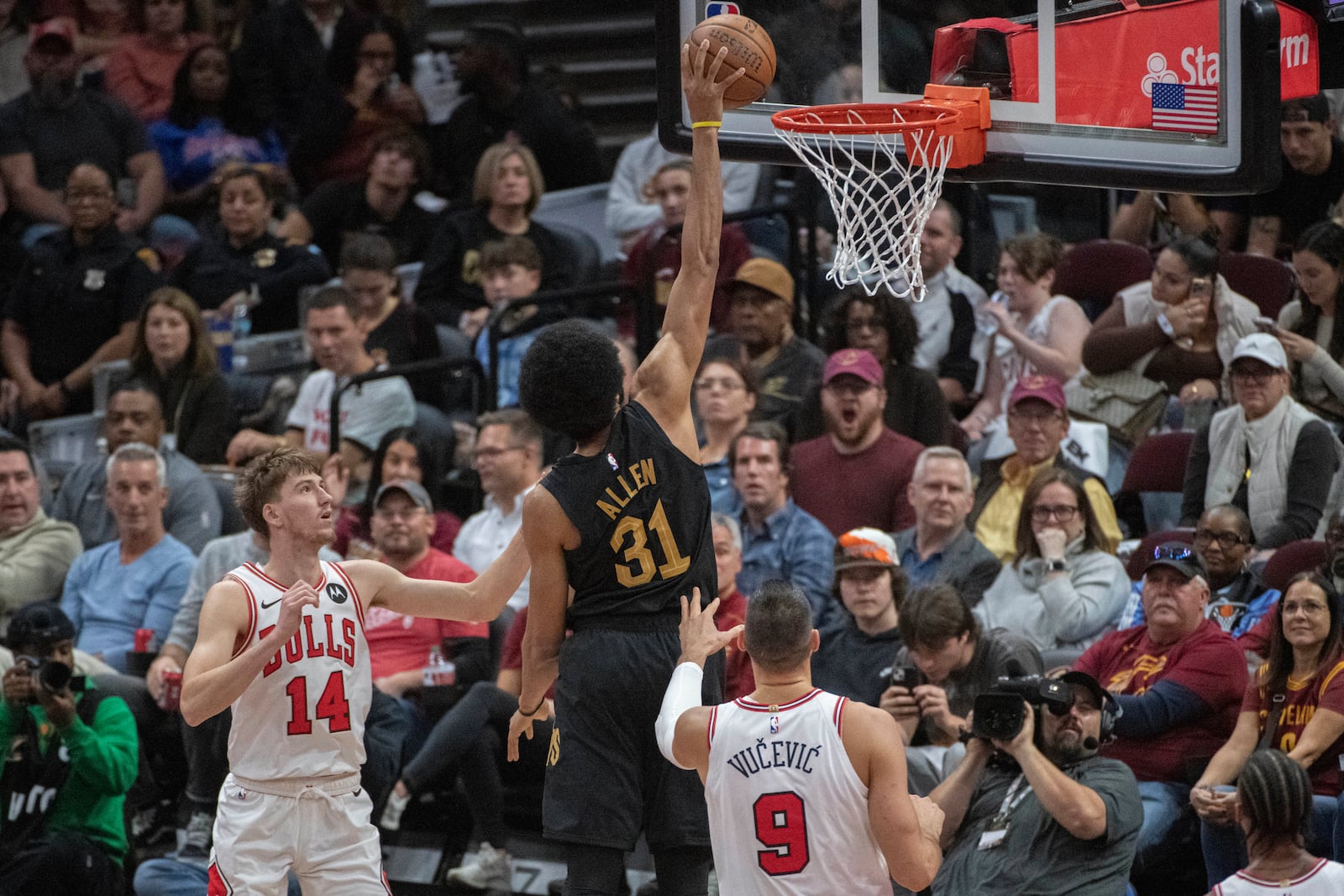 Cleveland Cavaliers' Jarrett Allen (31) dunks over Chicago Bulls' Matas Buzelis (14) and Nikola Vucevic (9) during the first half of an Emirates NBA Cup basketball game in Cleveland, Friday, Nov 15, 2024. (AP Photo/Phil Long)