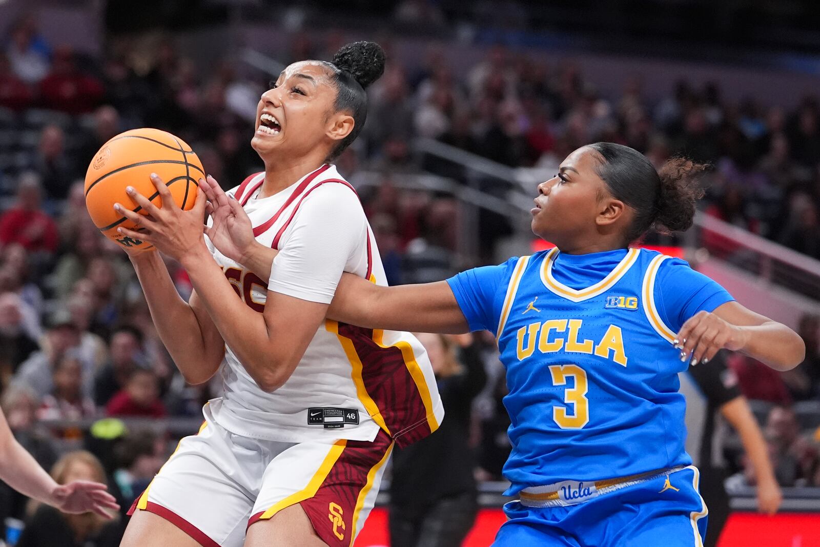 Southern California guard JuJu Watkins, left, grabs a rebound from UCLA guard Londynn Jones (3) during the first half of an NCAA college basketball game in the championship of the Big Ten Conference tournament in Indianapolis, Sunday, March 9, 2025. (AP Photo/Michael Conroy)