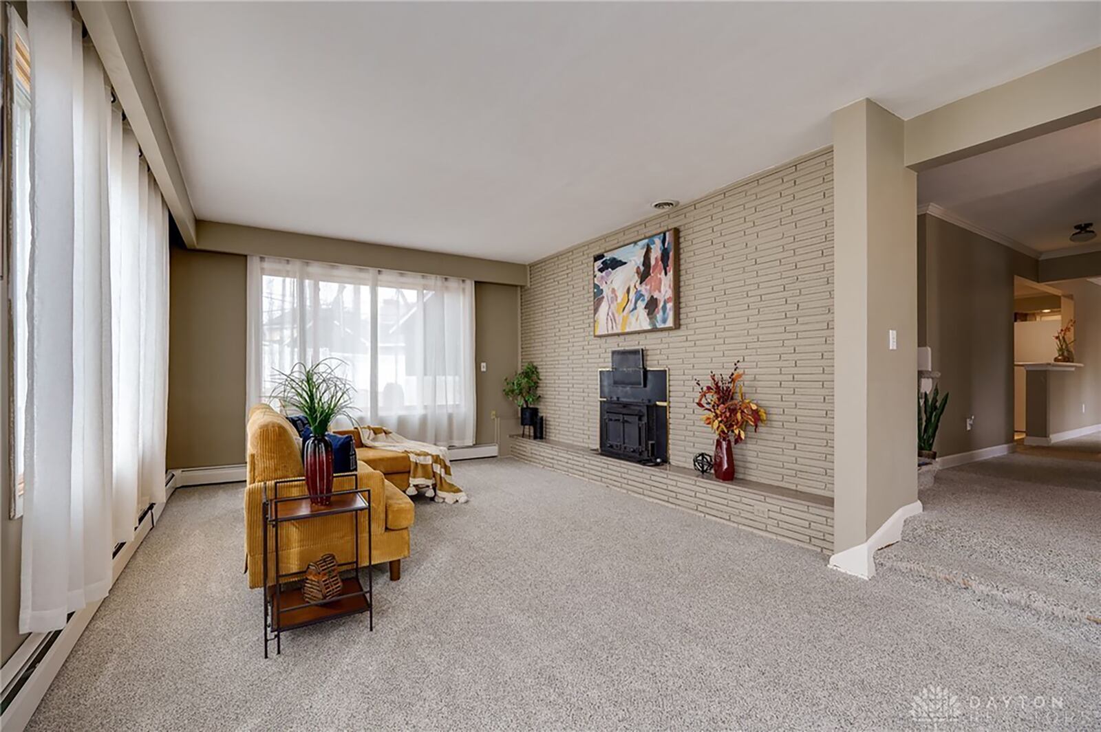 The sunken living room has new neutral carpeting and a woodburning fireplace with stove insert.