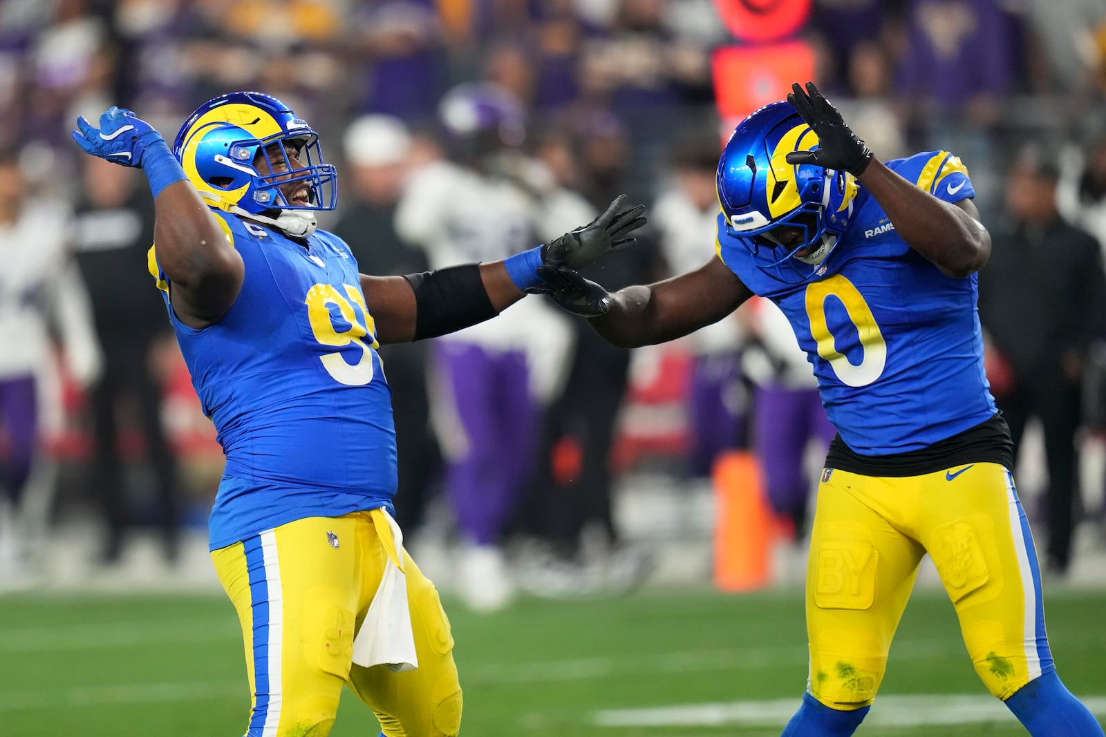 Los Angeles Rams defensive tackle Kobie Turner (91) celebrates his sack of Minnesota Vikings quarterback Sam Darnold with Byron Young (0) during the first half of an NFL wild card playoff football game, Monday, Jan. 13, 2025, in Glendale, Ariz. (AP Photo/Ross D. Franklin)