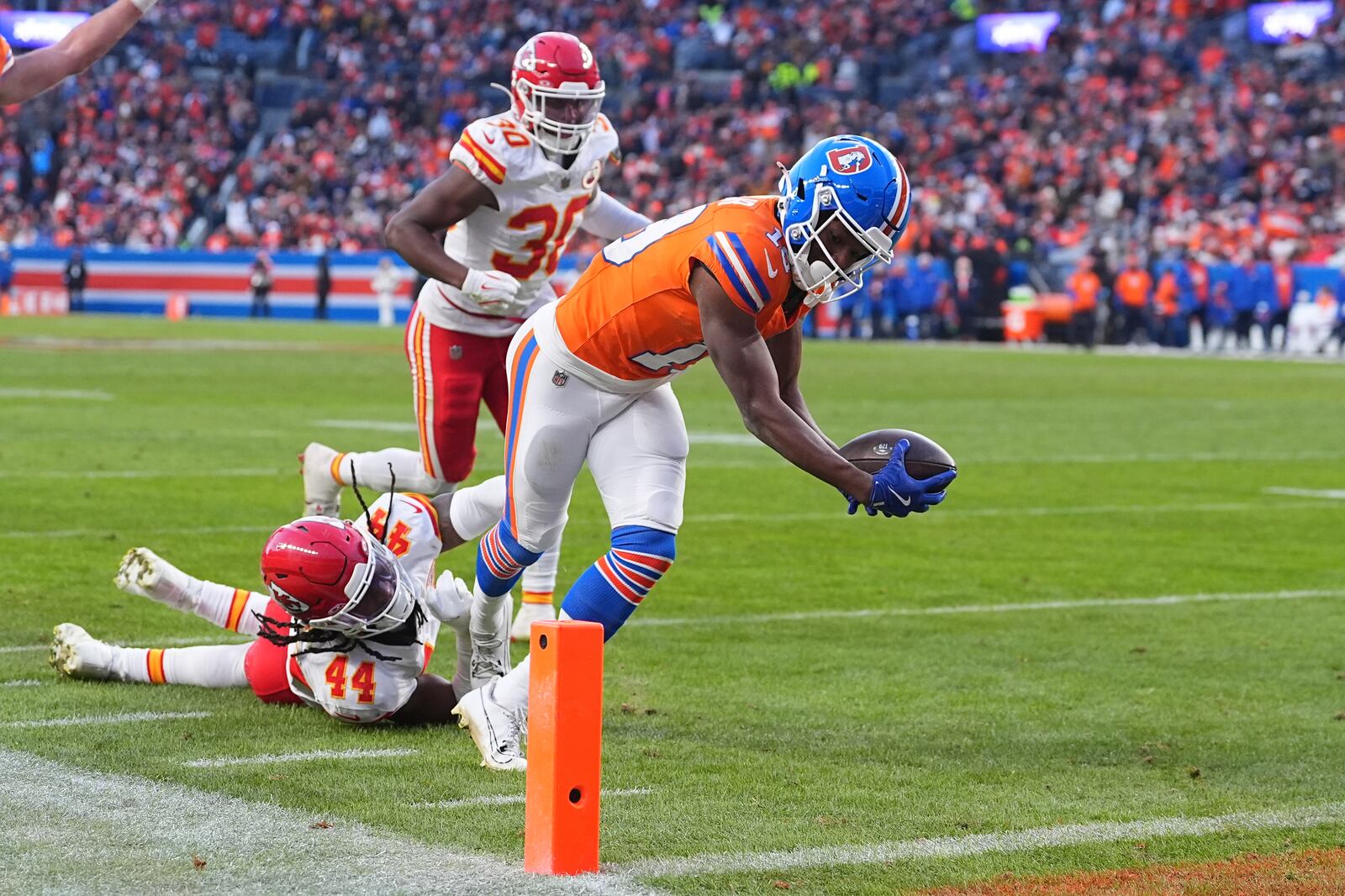 Denver Broncos wide receiver Marvin Mims Jr. scores past Kansas City Chiefs linebacker Cam Jones (44) and Chris Roland-Wallace (30) during the second half of an NFL football game Sunday, Jan. 5, 2025, in Denver. (AP Photo/David Zalubowski)