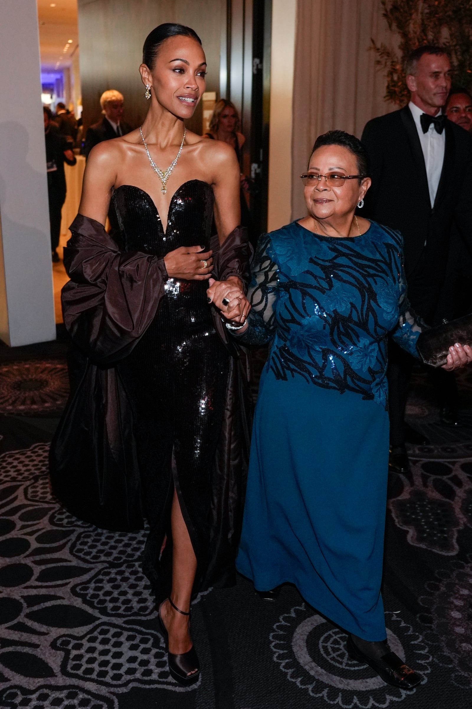 Zoe Saldana, left, and Asalia Nazario arrive at the 82nd Golden Globes on Sunday, Jan. 5, 2025, at the Beverly Hilton in Beverly Hills, Calif. (AP Photo/Chris Pizzello)