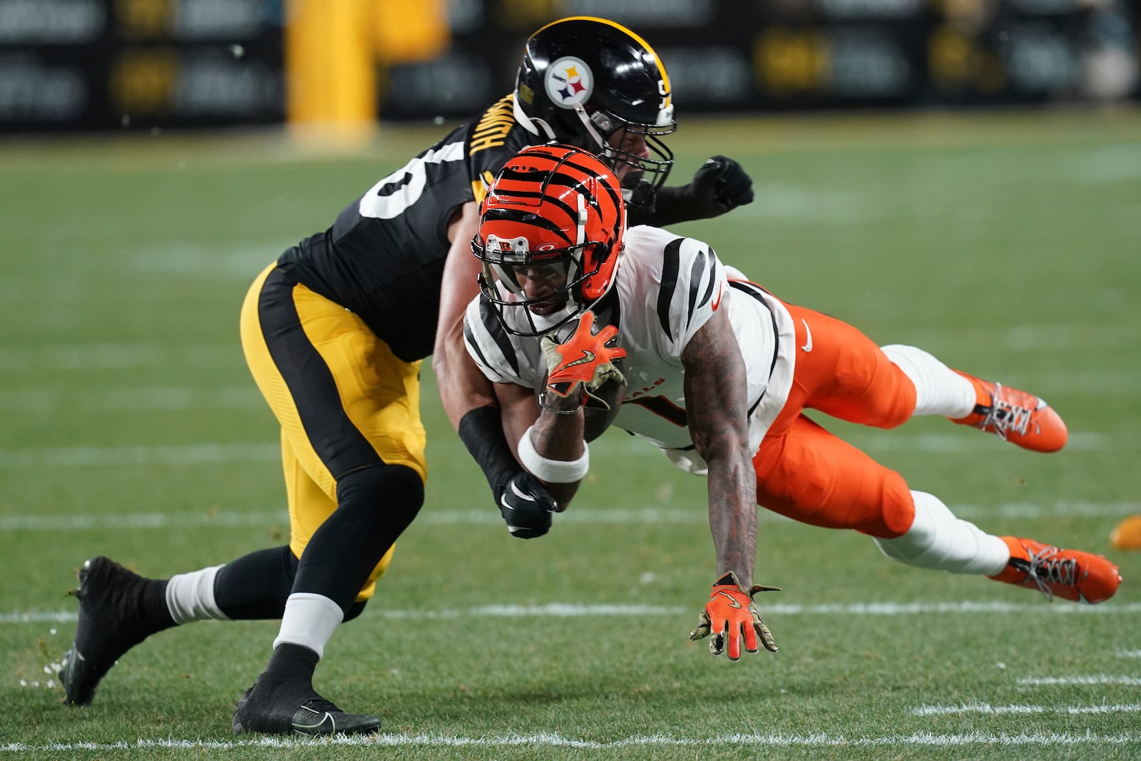 Cincinnati Bengals wide receiver Ja'Marr Chase (1) picks up a first down defended by Pittsburgh Steelers linebacker Alex Highsmith (56) during the first half of an NFL football game in Pittsburgh, Saturday, Jan. 4, 2025. (AP Photo/Matt Freed)