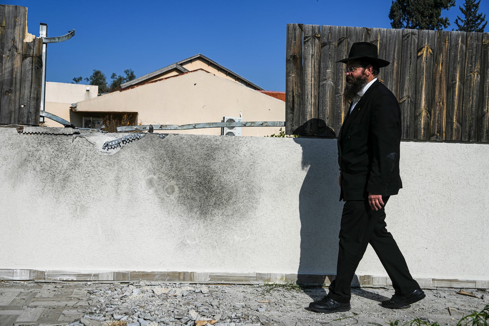 A man surveys a damaged home after a rocket fired by Palestinian militants from Gaza Strip hit in the town of Sderot, southern Israel Monday, Jan. 6, 2025. (AP Photo/Tsafrir Abayov)