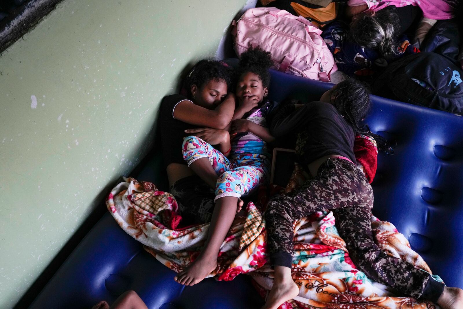 Venezuelan migrant Estebani Llerena, left, sleeps next to her daughter in Puerto Cartí, on Panama's Caribbean coast, Saturday, Feb. 23, 2025, where they plan to take a boat to Colombia after giving up hopes of reaching the U.S. while in southern Mexico amid President Trump's crackdown on migration. (AP Photo/Matias Delacroix)