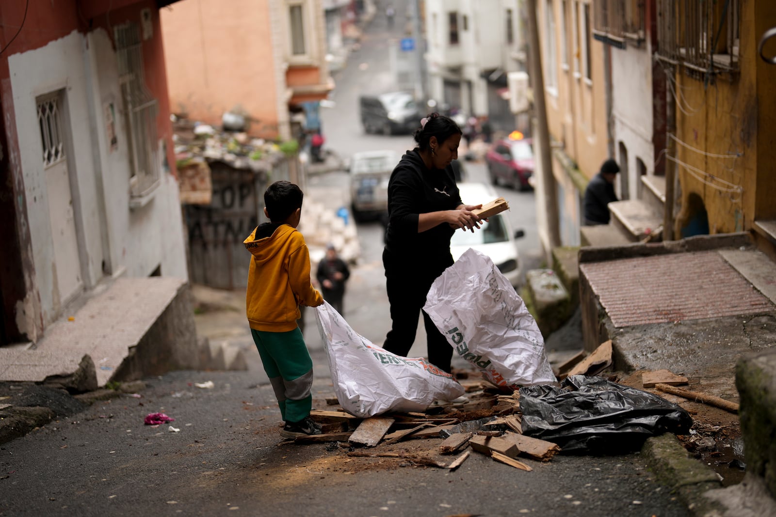 Residents gather pieces of wood to burn for heat in the Tarlabasi neighborhood in Istanbul, Turkey, Wednesday, Dec. 4, 2024. (AP Photo/Francisco Seco)