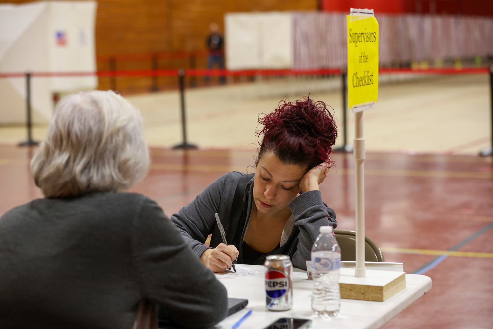 Brooke Younge registers to vote in Derry, N.H., Tuesday, March 11, 2025. (AP Photo/Reba Saldanha)