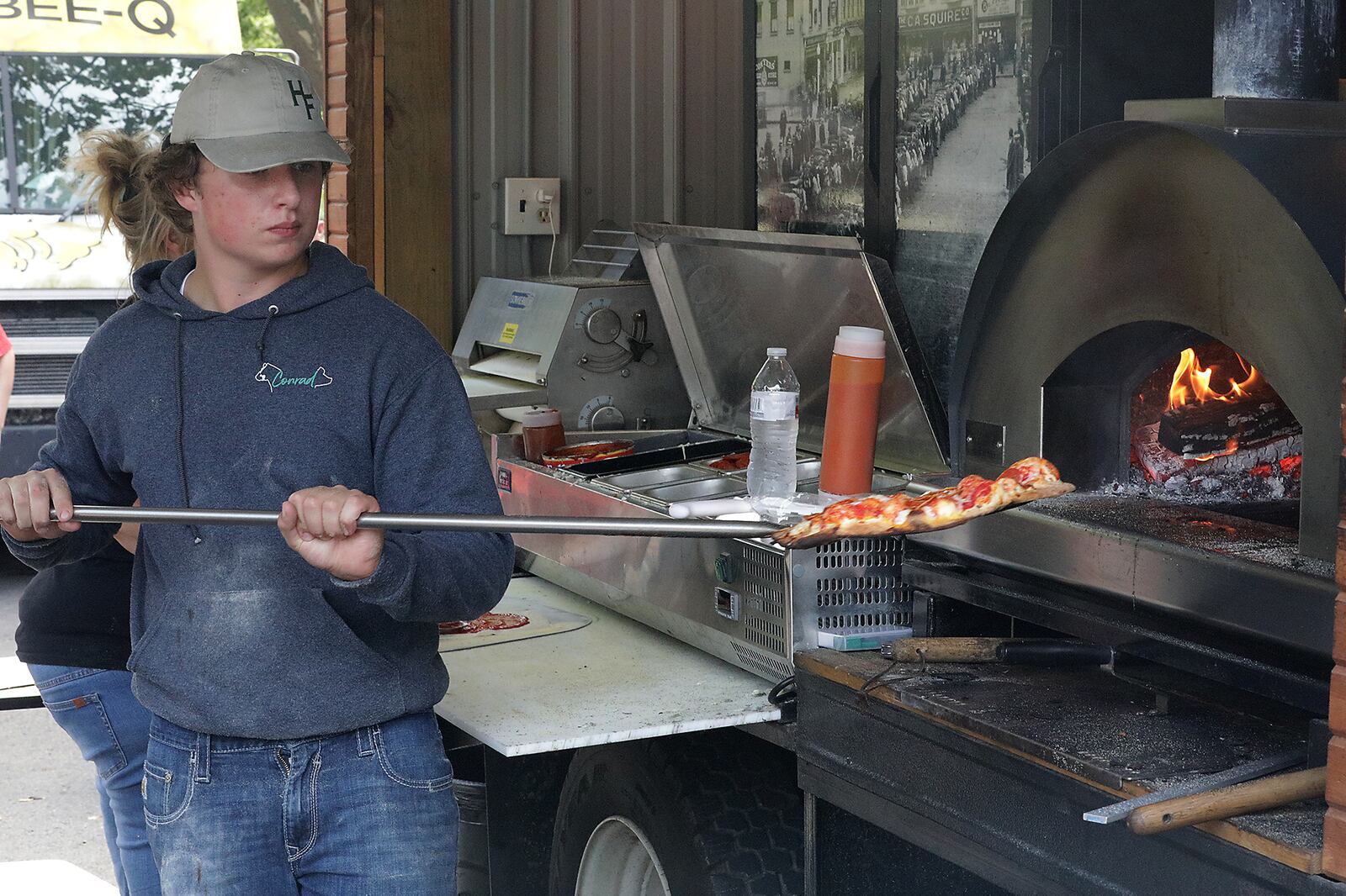 A vendor takes a wood fired pizza out of the oven Saturday during the Springfield Rotary Gourmet Food Truck Competition. BILL LACKEY/STAFF