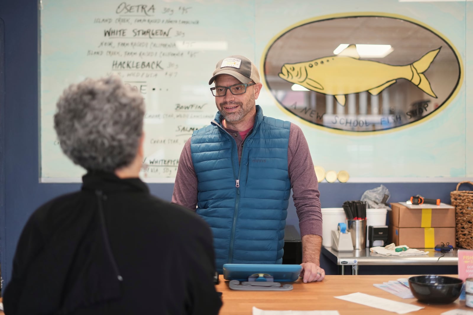 Bryan Szeliga owner of Fishtown Seafood speaks with a customer at his shop in Haddonfield, N.J., Thursday, March 6, 2025. (AP Photo/Matt Rourke)