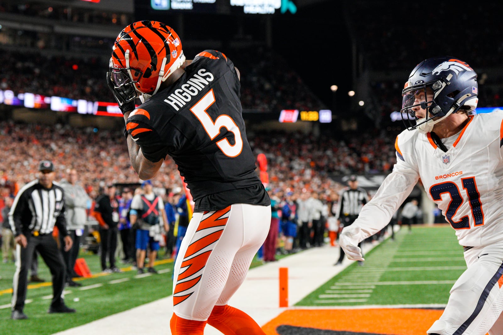 Cincinnati Bengals wide receiver Tee Higgins (5) makes a catch for a touchdown in front of Denver Broncos cornerback Riley Moss (21) during the second half of an NFL football game in Cincinnati, Saturday, Dec. 28, 2024. (AP Photo/Jeff Dean)