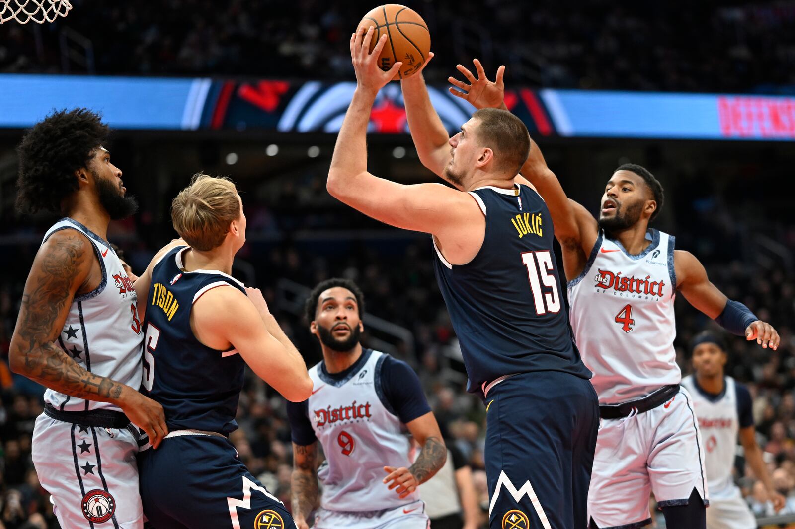 Denver Nuggets center Nikola Jokic (15)looks to score a basket past Washington Wizards guard Jared Butler (4) during the second half of an NBA basketball game Saturday, Dec. 7, 2024, in Washington. (AP Photo/John McDonnell)