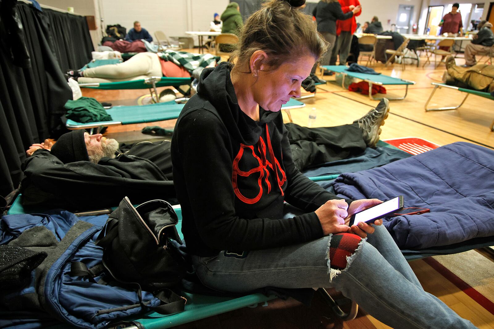 Melissa and her brother-in-law, Greg, relax on the cots in the gymnasium of the Springfield Salvation Army Tuesday, Jan. 16, 2024. The City of Springfield is partnering with the Nehemiah Foundation Faith Community Crisis Response Team, the Salvation Army, Sheltered Inc. and Homefull and has opened an Extreme Cold Weather Homeless Shelter to help those living on the street escape the bitter cold. BILL LACKEY/STAFF