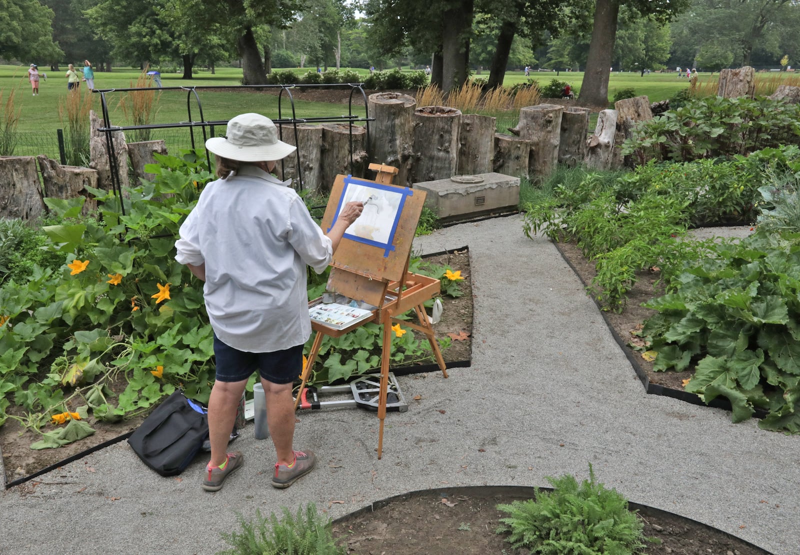 Kyna Paul paints in the Garden of Eatin' at the Snyder Park Gardens and Arboretum Saturday during the Gardens' Jubilee celebrating the garden's official grand opening.  BILL LACKEY/STAFF