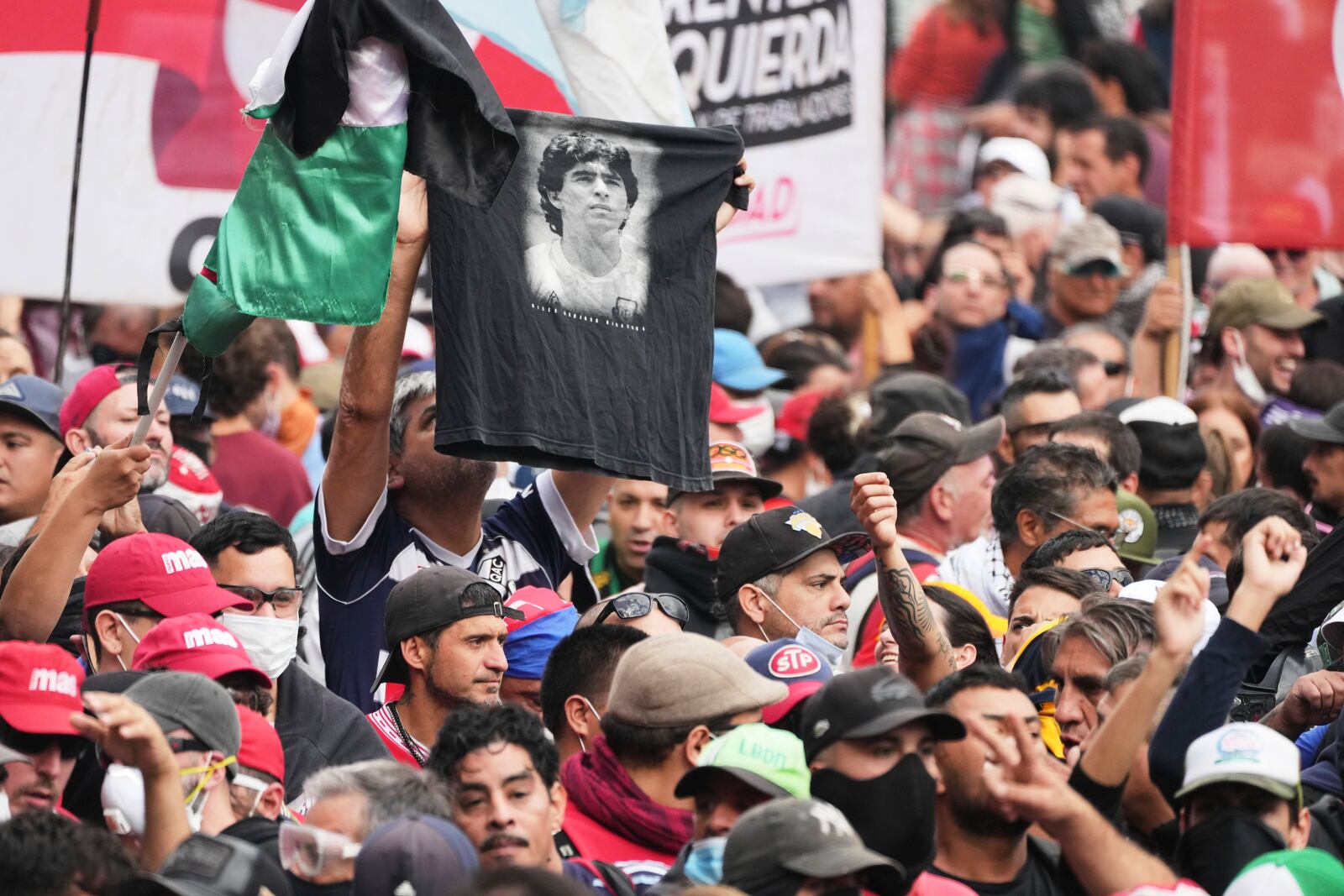 A soccer fan holds up a shirt with a photo of late soccer star Diego Maradona during a protest with retirees for higher pensions and against austerity measures implemented by Javier Milei's government in Buenos Aires, Argentina, Wednesday, March 12, 2025. (AP Photo/Natacha Pisarenko)