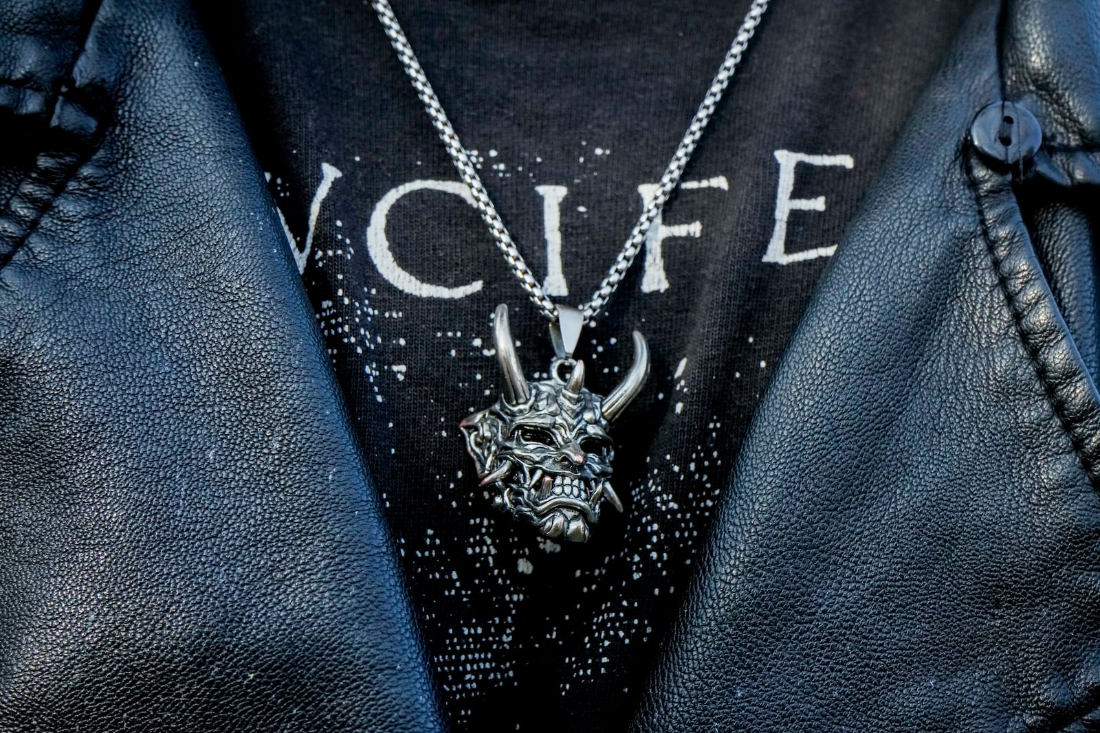 A member of The Temple of Satan: Satanists and Luciferians of Chile, wears a pendant depicting Satan during a ceremony at the General Cemetery in Santiago, Saturday, Sept. 14, 2024. (AP Photo/Esteban Felix)