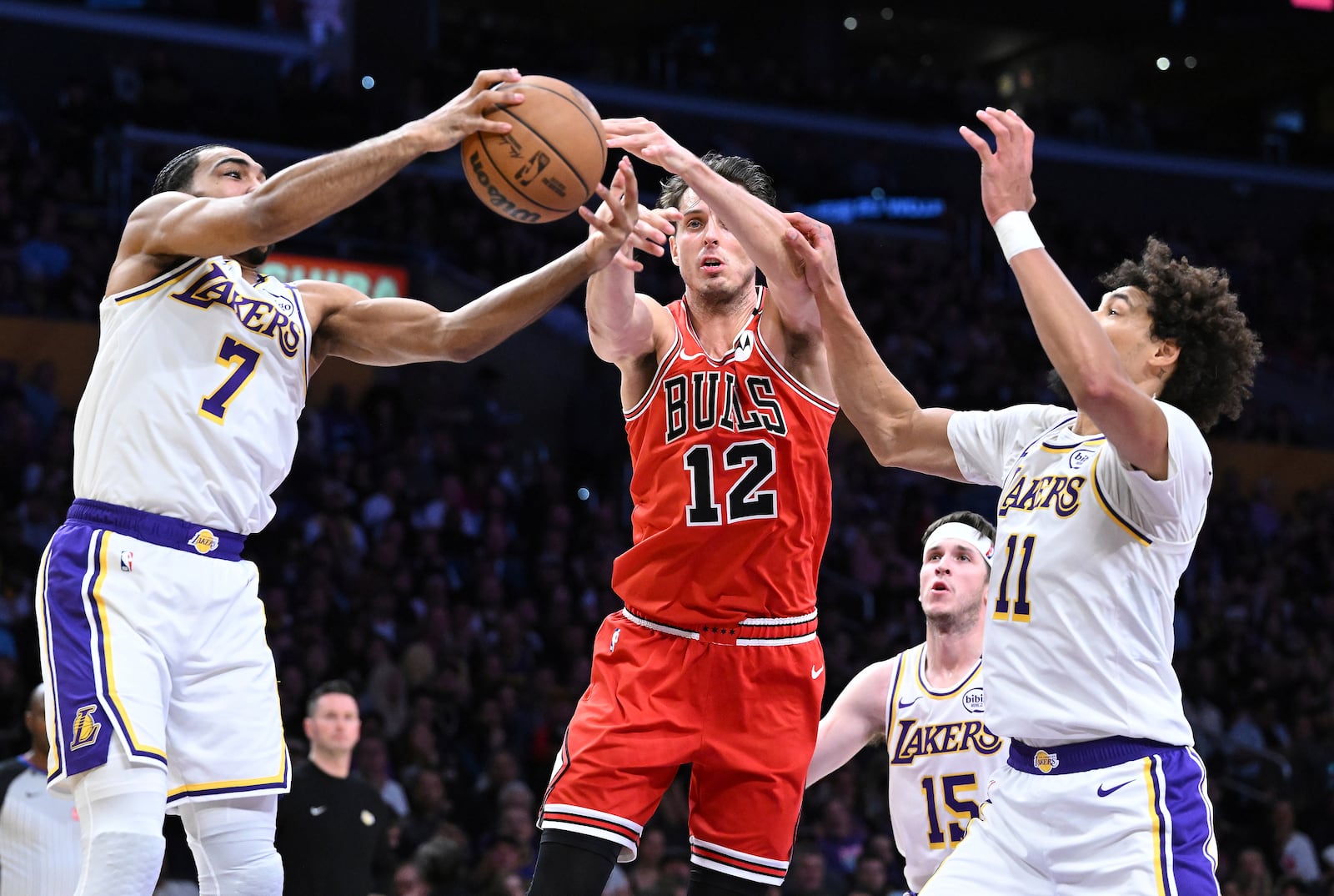 Chicago Bulls forward Zach Collins (12) battles for a rebound with Los Angeles Lakers guard Gabe Vincent (7) and center Jaxson Hayes (11) in the first half of an NBA basketball game Saturday, March 22, 2025, in Los Angeles. (AP Photo/Wally Skalij)