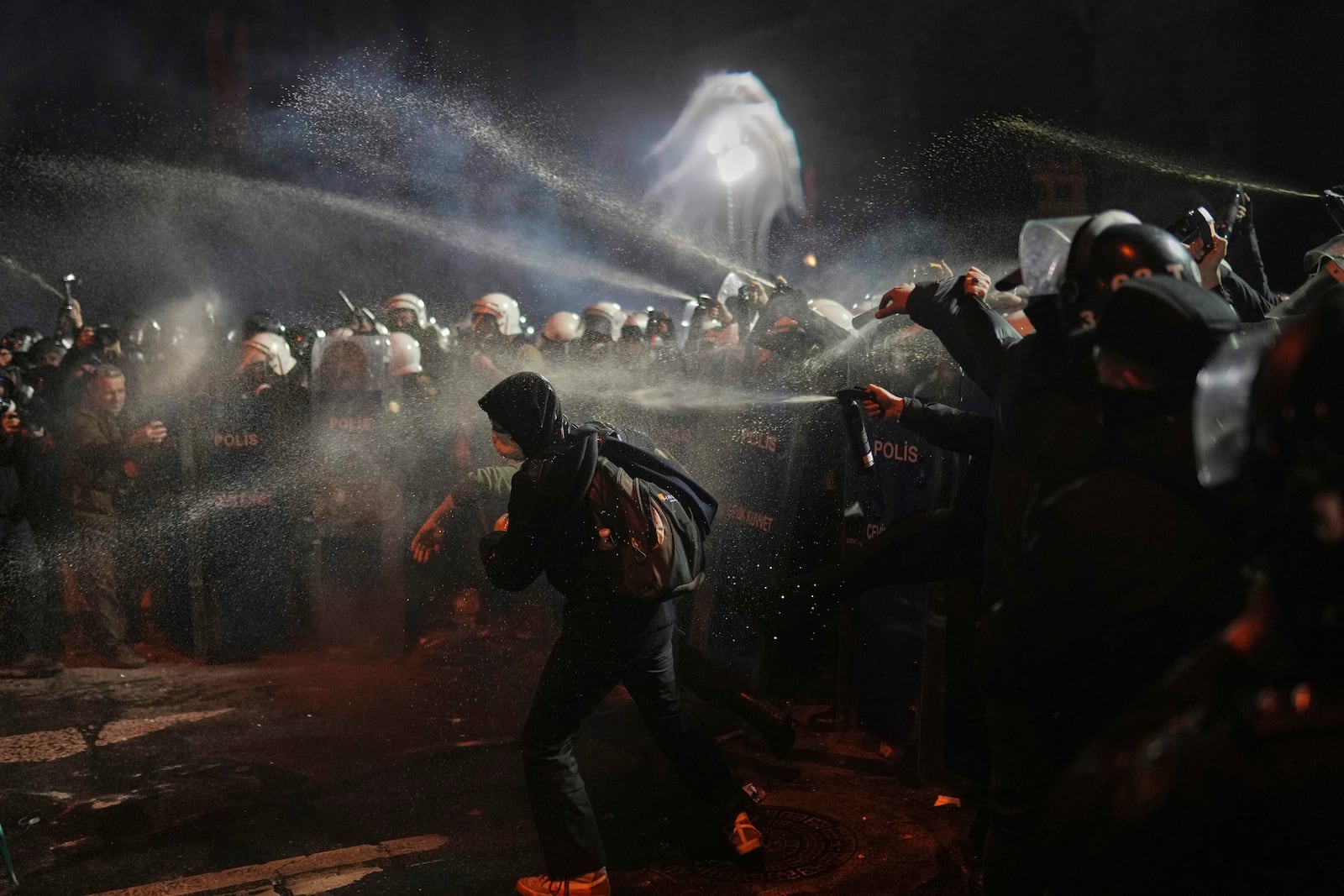 Riot police use pepper spray to clear protesters during a protest against the arrest of Istanbul's Mayor Ekrem Imamoglu, in Istanbul, Turkey, Saturday, March 22, 2025. (AP Photo/Francisco Seco)