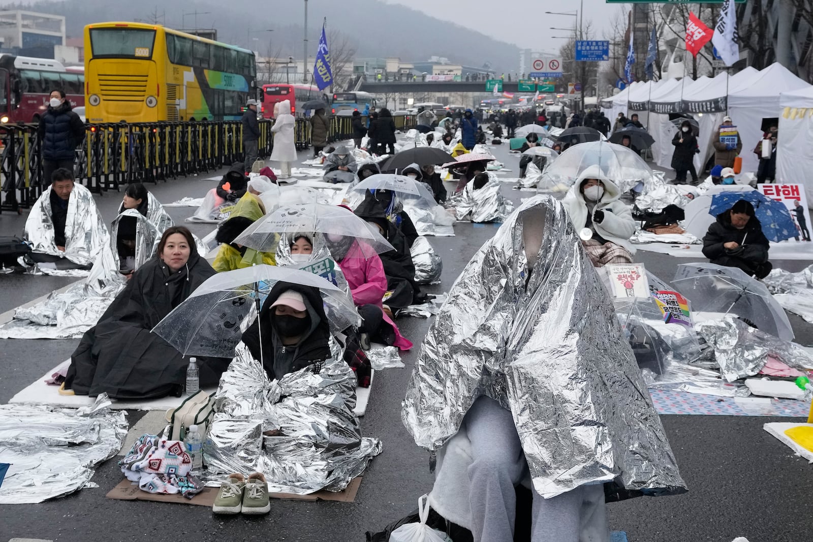 Protesters wait for a rally demanding the arrest of impeached South Korean President Yoon Suk Yeol near the presidential residence in Seoul, South Korea, Monday, Jan. 6, 2025. (AP Photo/Ahn Young-joon)