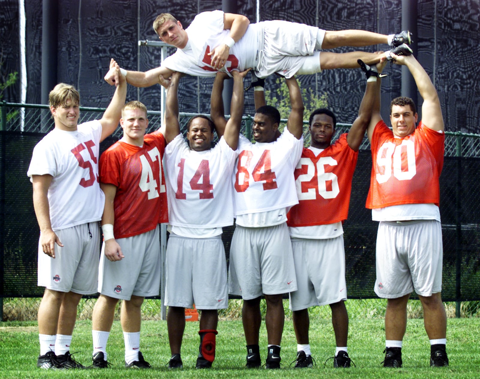 Seven scholarship players from the Miami Valley are currently playing on the OSU Buckeye football team. They are L-R: Nick Mangold, A.J. Hawk, Angelo Chattams, John Hollins, Will Allen, and Quinn Pitcock all hold kicker Mike Nugent above their heads.