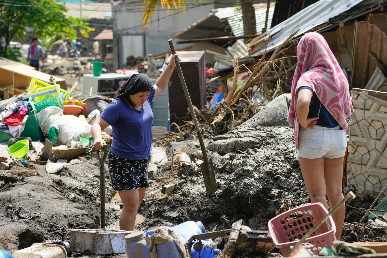 Residents try to recover belongings from their damaged homes after a recent landslide triggered by Tropical Storm Trami struck Talisay, Batangas province, Philippines leaving thousands homeless and several villagers dead on Saturday, Oct. 26, 2024. (AP Photo/Aaron Favila)