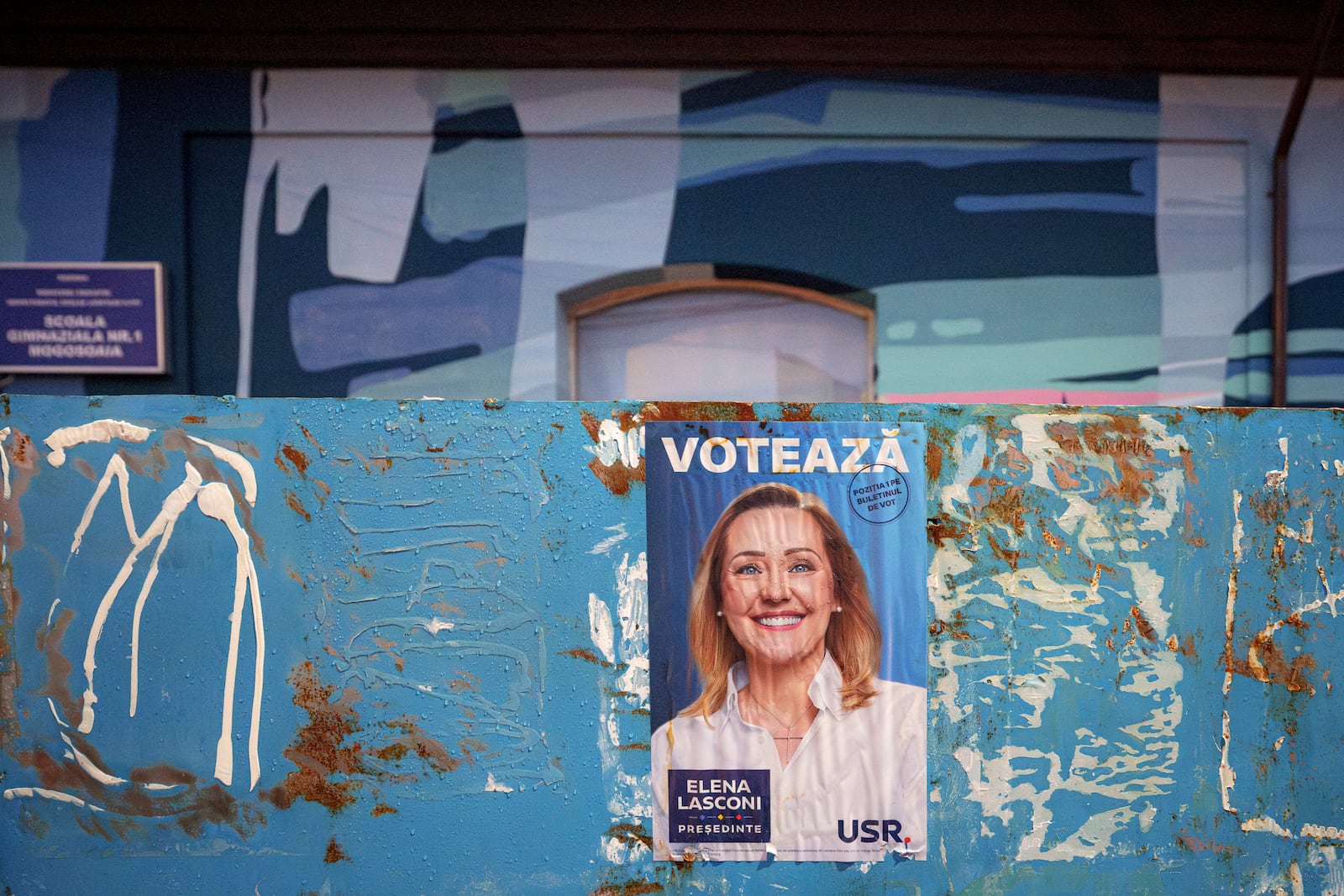 A poster of Elena Lasconi, presidential candidate who entered the presidential runoff in second position, is placed outside the closed voting station where Calin Georgescu, an independent candidate for president who won the first round of presidential elections, was supposed to vote, after Romania's Constitutional Court annulled the first round of presidential elections, in Mogosoaia, Romania, Sunday, Dec. 8, 2024. (AP Photo/Andreea Alexandru)