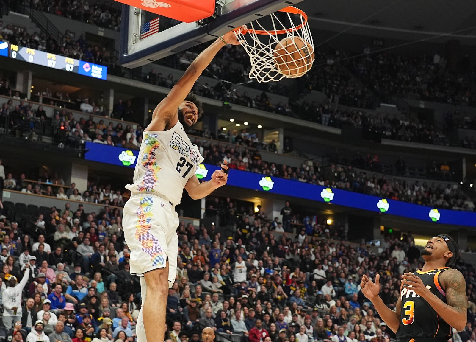 Denver Nuggets guard Jamal Murray, left, dunks as Phoenix Suns guard Bradley Beal, right, covers in the second half of an NBA basketball game Friday, March 7, 2025, in Denver. (AP Photo/David Zalubowski)